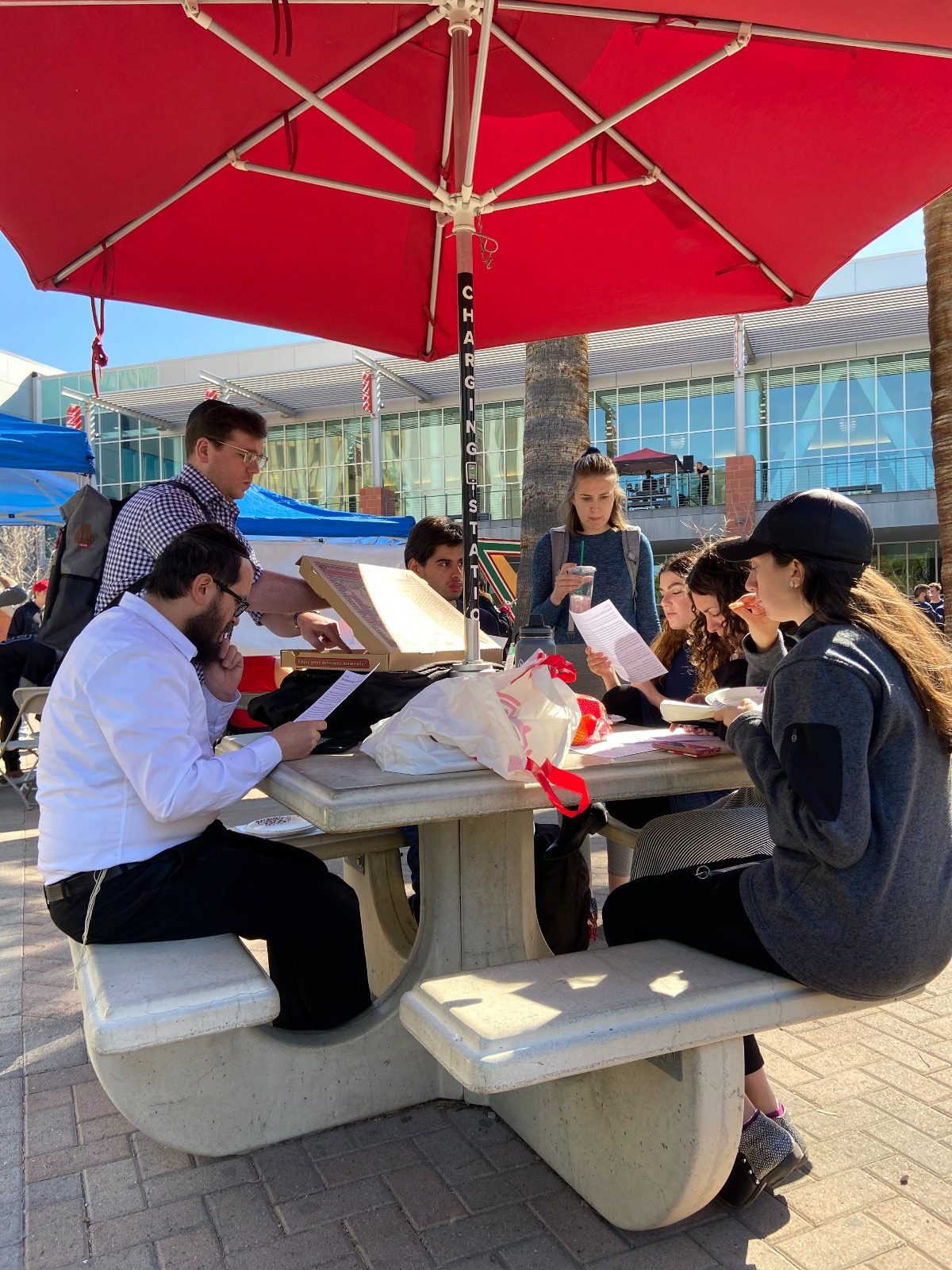 Pizza and Parsha under the red umbrella on campus